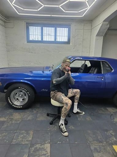 Nic Schwalenberg, Inhaber von nic's wrap lab, in der Werkstatt vor einem blauen Oldtimer