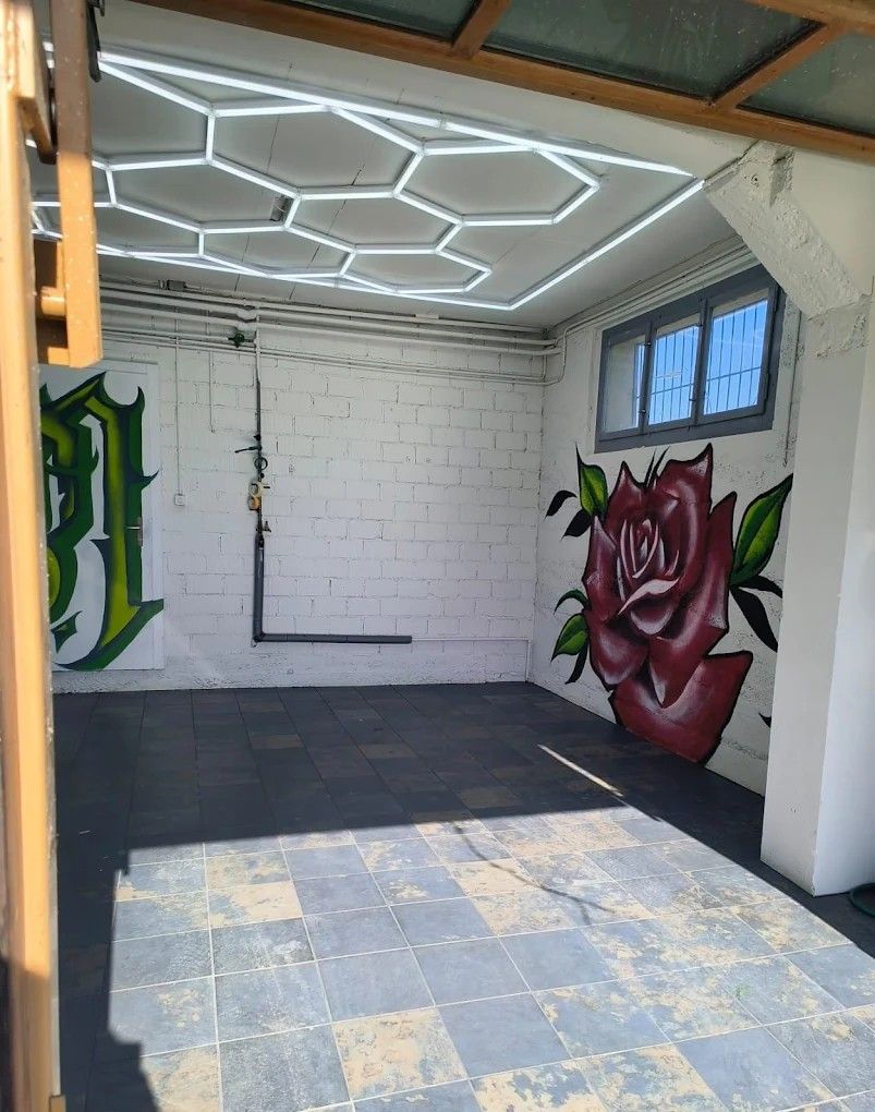 Werkstatt von nic's wrap lab in Hallwil mit Wabenlicht an der Decke und Rosen-Graffiti an der Wand